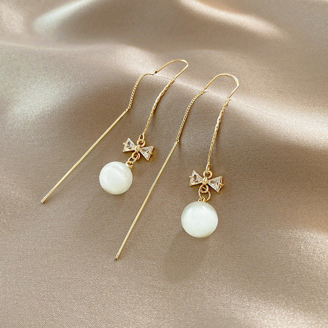 Golden pearl bow dangle earrings